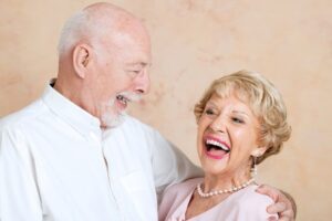 Happy couple in Long Beach, CA after a successful denture treatment.